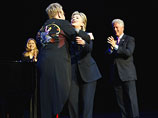 Перед исполнением своих главных хитов сэр Элтон, появившийся на сцене в длинном смокинге, украшенном яркими аппликациями, заключил Клинтон в объятия