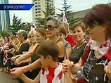 Десятки тысяч жителей Тбилиси вышли в понедельник на улицы с государственными флагом в руках и соединяют руки в "живые цепи" с призывом к Европе и всему миру выступить против действий России и поддержать Грузию