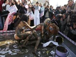 Грязью поливали украинские политические силы: во время приготовлений перед поединком полуобнаженным девушкам в купальниках цветов основных политических сил дорисовывали на лицах партийные эмблемы Грязью поливали украинские политические силы: во время приготовлений перед поединком полуобнаженным девушкам в купальниках цветов основных политических сил дорисовывали на лицах партийные эмблемы