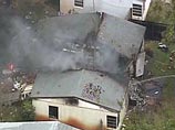 Маленький самолет протаранил насквозь одноэтажный дом и взорвался в районе города Форт-Лодердейл в штате Флорида. Пожарные расчеты тушат возгорание