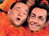 А также и президент Франции Николя Саркози в обнимку с итальянским коллегой Сильвио Берлускони в оранжевых боа, восклицающие "Let's go party!" ("Идем на праздник!")