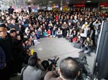 Жители Сеула на одной из станций метрополитена смотрят трансляцию выступления южнокорейской фигуристки Ким Ю На
