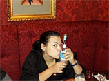 На двух оставшихся фотографиях в баре судья целует водку марки "Журавли", на другой - пьет эту же водку из горла