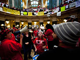 В американском штате Висконсин идут массовые акции протеста против уменьшения дотаций госслужащим, предложенного губернатором штата Скоттом Уолкером ради сокращения дефицита местного бюджета