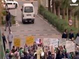 Люди, размахивающие ливийскими национальными флагами, говорят, что готовы защитить своего вождя и свою страну собственными телами