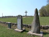 Памятный камень стоит всего в ста метрах от братской могилы, где похоронены советские воины