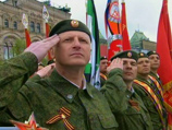 Во время приветствия военнослужащих Медведев и Путин стояли, но позже присели на свои места на специально выстроенной трибуне