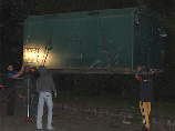 Накануне ночью к руинам подъехали грузовики со строительными вагончиками, после чего кран начал их выгружать на землю