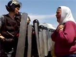 На видео с места событий запечатлены моменты, когда бойцы выставляют сплошную стену щитов перед старушкой в платке, которая от страха только молится и осеняет вокруг себя крестами