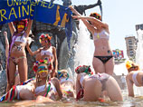 13 активисток украинского женского движения FEMEN провели акцию протеста против летних плановых отключений горячей воды в Киеве, искупавшись в фонтане возле Ляцких ворот на площади Независимости в четверг