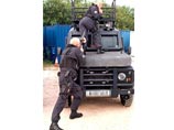 На фото один из бойцов позирует на капоте бронированного Land Rover Defender, в то время как другой целится ему в зад из дробовика. По видимому, оружие при этом не заряжено. Оба одеты в полицейскую форму и имеют при себе пистолеты Glock с боевыми патронам На фото один из бойцов позирует на капоте бронированного Land Rover Defender, в то время как другой целится ему в зад из дробовика. По видимому, оружие при этом не заряжено. Оба одеты в полицейскую форму и имеют при себе пистолеты Glock с боевыми патронам