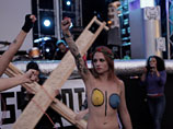 У одной из активисток на теле нарисован цветной логотип движения, у двух других на груди и животе надписи