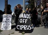 Демонстранты протестуют против плана спасения экономики Кипра перед зданием парламента в Никосии