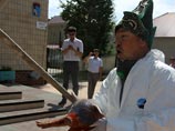 Сам Ахмедьяров был одет в защитный костюм белого цвета, а на голову водрузил казахскую шапку