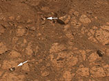 Ученые выдвинули две версии происхождения камня: первая состояла в том, что он был каким-то образом выброшен колесом марсохода, а вторая - что этот фрагмент породы был выбит ударом метеорита