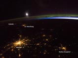 На сайте NASA опубликована фотография ночной Москвы, на которой видны огни Нижнего Новгорода, Санкт-Петербурга и Хельсинки, а также зеленоватое северное сияние и голубое свечение атмосферы Земли