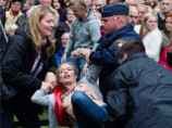В Швеции Femen прервала речь премьер-министра: он замолчал, увидев подбежавших к сцене и оголившихся женщин