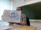 Педагог демонстрирует экзаменуемым запечатанный конверт с заданиями перед началом Единого Государственного экзамена по литературе в гимназии города Новосибирска