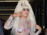 Lady Gaga прибыла в международный токийский аэропорт Нарита во вторник в блестящем почти прозрачном костюме с прикрывающими грудь накладками в виде морских раковин и на высоких "платформах"