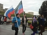 В толпе видны флаги ДНР, "Справедливой России". Участники акции требуют международного расследования убийств, жертвы которых обнаружены близ Донецка