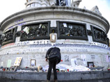 Монумент, на который были возложены цветы, фотографии и рукописные послания, установлен на площади Республики в центре Парижа