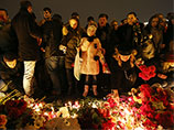 Жители пришли семьями, чтобы почтить память погибших и возложить цветы у Александровской колонны