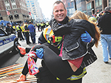 Фотография окровавленной девушки, которую на руках несет бостонский пожарный Джеймс Плурд, стала одним из символов трагедии и получила известность во всем мире