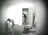 Оперативная съемка зафиксировала, как бандиты ворвались в квартиру, повалили хозяина на пол и попытались заткнуть ему рот.