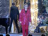 Элтон Джон появился перед ожидавшей его публикой в красном костюме со сверкающей надписью на спине