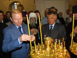 Президент Украины Леонид Кучма ставит свечу во время торжественной службы в честь празднования 950-летия Киево-Печерской лавры