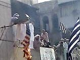 Демонстранты потрясали в воздухе кулаками, жгли американские флаги и избивали чучело Джорджа Буша и британского премьера Тони Блэра