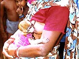 Индийская женщина вскармливает грудью мартышку