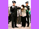 Китайские полицейские задерживают одного из участников акции протеста против преследований последеователей 'Фалуньгун'