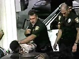 Полицейский поднял задержанного, на которого уже были надеты наручники, и буквально швырнул его на кузов автомобиля