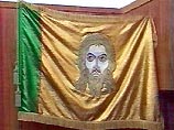 Новый флаг - золотистое полотнище с вертикальной зеленой полосой вдоль древка, а посередине изображение лика Христа с образа Спаса Нерукотворного