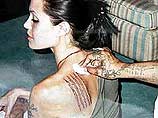 Джоли решила "лечь под иглу" в Таиланде, чтобы украсить свое левое плечо черной татуировкой, состоящей из пяти вертикальных рядов древних кхмерский надписей
