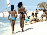 Бывший банкир Рольф Дж, родом из немецкого города Оснабрюк, в шортах-бермудах наслаждается жарким флоридским солнцем, лежа на пляже в Майами