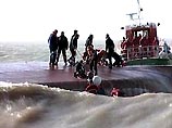 Они стремятся вызволить из трюма перевернувшегося, но остающегося на поверхности каботажного судна шесть моряков Они стремятся вызволить из трюма перевернувшегося, но остающегося на поверхности каботажного судна шесть моряков