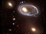 На снимке видно, как похожее на алмазный браслет кольцо ярчайших голубых звезд окружает то, что некогда было нормальной спиральной галактикой