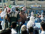 В "назидание" другим вооруженные люди в масках провезли "виновных" на пикапе по улицам Эль-Фаллуджи, демонстрируя всем их голые спины со следами побоев