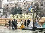 Сейчас на углу Крещатика и улицы Городецкой разбиты 7 палаток. Территория городка под названием "Зона, свободная от Кучмы" огорожена веревкой, на которой висят плакаты Сейчас на углу Крещатика и улицы Городецкой разбиты 7 палаток. Территория городка под названием "Зона, свободная от Кучмы" огорожена веревкой, на которой висят плакаты