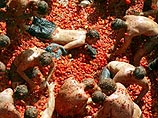 В Испании на фестивале La Tomatina 30 тысяч человек перекидали друг в друга тонны помидоров