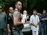 Боец спецназа несет ребенка, находившегося в заложниках в школе Боец спецназа несет ребенка, находившегося в заложниках в школе