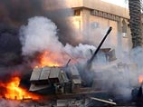 Американские вертолеты, выпустили ракеты и обстреляли из пулеметов толпу людей, собравшихся возле горящего американского танка на улице Хайфа в центре иракской столицы