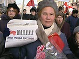 В руках активисты "Трудовой России" держат красные флаги, а также плакаты с изображением Ленина