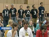 Как сообщается в пресс-релизе группы, размещенном на ее сайте, во время выступления президента несколько активистов встали на стулья и с помощью больших белых букв, начертанных на своих черных футболках, составили лозунг "НЕТ АЭС!" Как сообщается в пресс-релизе группы, размещенном на ее сайте, во время выступления президента несколько активистов встали на стулья и с помощью больших белых букв, начертанных на своих черных футболках, составили лозунг "НЕТ АЭС!"