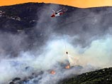 Пожарные в настоящий момент используют вертолеты и самолеты для сбрасывания воды на горящие участки леса, чтобы локализовать очаги возгорания