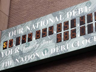После того, как сумма долга преодолела планку 10 трлн долл, так называемые "Часы национального долга" зашкалили и то что раньше было знаком доллара поменялось на цифру 1, а доллар приклеили рядом