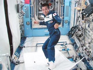 Стоя на куске белой материи, Коити Ваката плавно скользил по кабине Международной космической станции