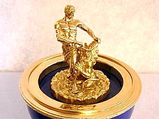Яйцо "Самсон" - серебряное, покрыто темно-синей гильошированной эмалью. Венчает изделие трехглавый царский орел, как на Корпусе под гербом Большого петергофского дворца